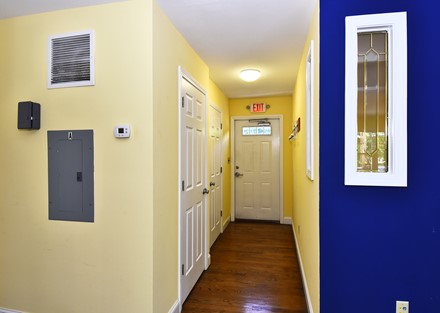 Rear hall with 1/2 bath. Shows separate electric panel.